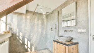 Bathroom showcasing wooden sink and floor, with mallet tile installation.