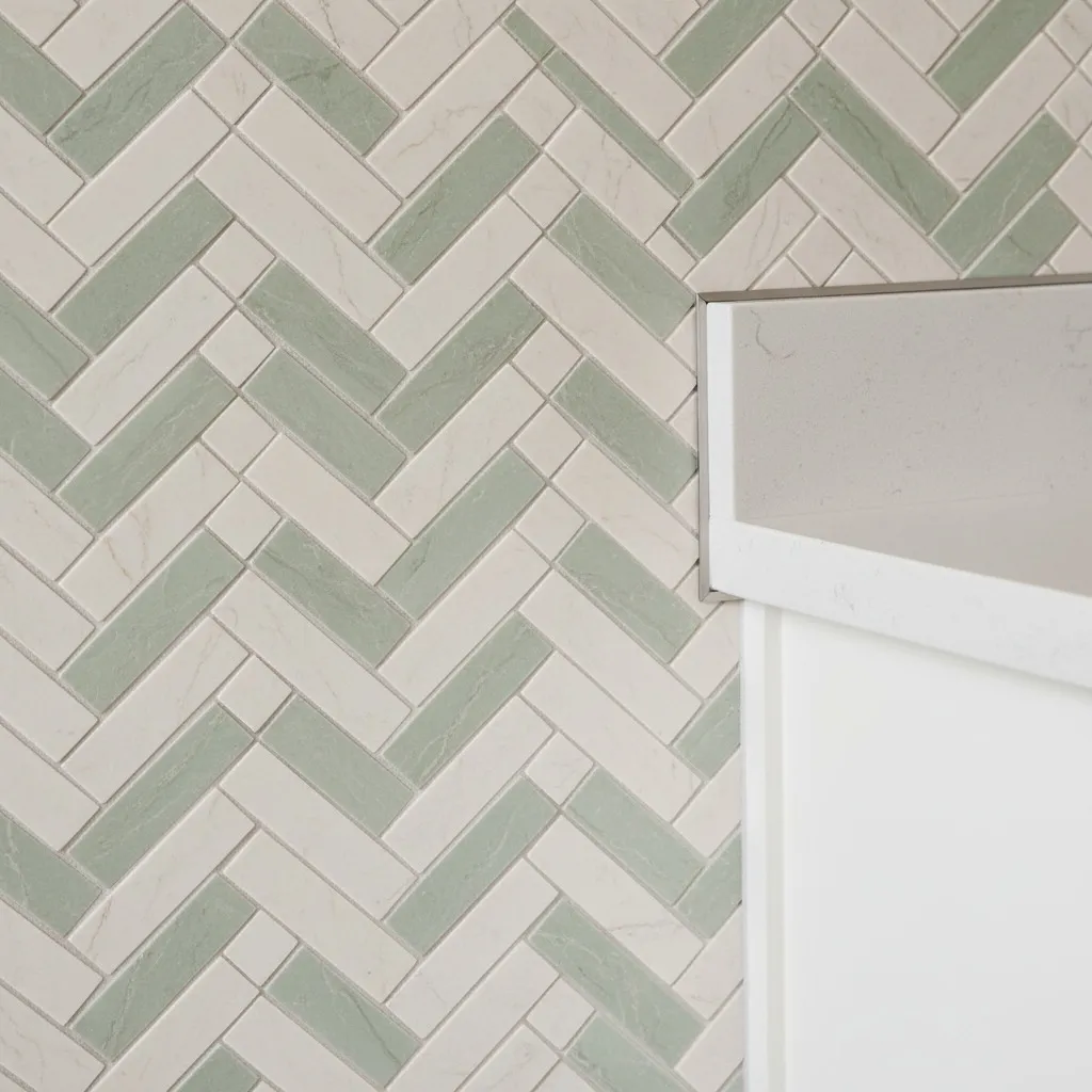 Close-up finished mosaic corner with slim metal profile and colour-matched silicone, 2 mm grout