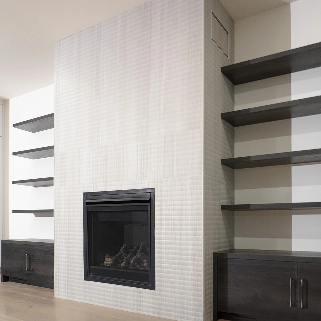 Floor-to-ceiling textured porcelain fireplace surround with dark oak floating shelves and unlit insert