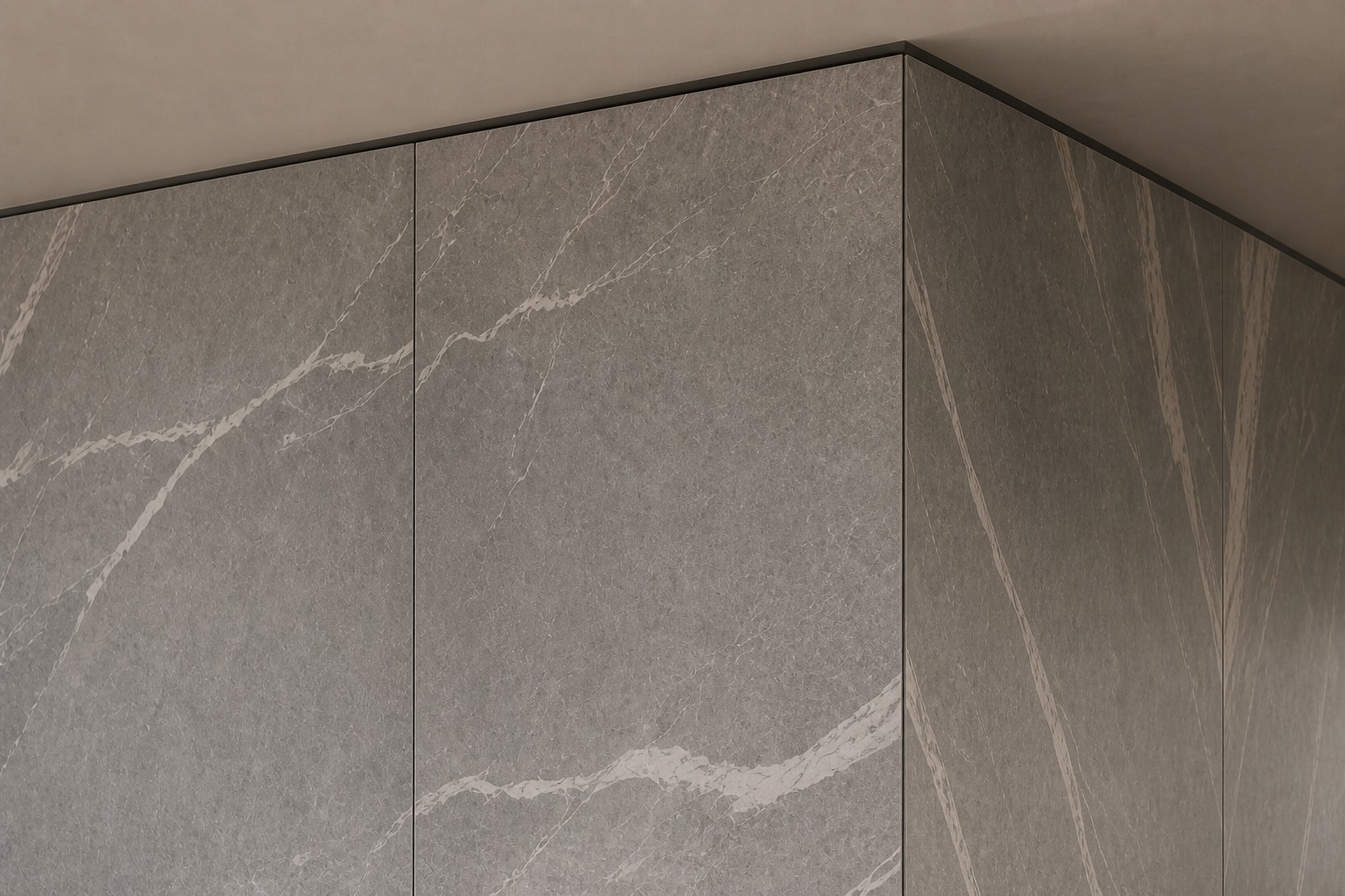 Close view of a grey porcelain-panel outside corner with continuous veining